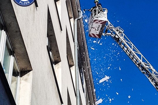 Led ze střechy ohrožoval chodce u zastávky na Slovanech